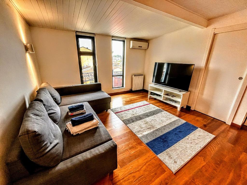 a living room with a couch and a flat screen tv at Deluxe Apartament - Marina di Carrara - in Marina di Carrara