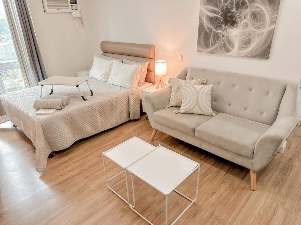 a living room with a bed and a couch at Abreeza Place WIFI & Netflix in Davao City
