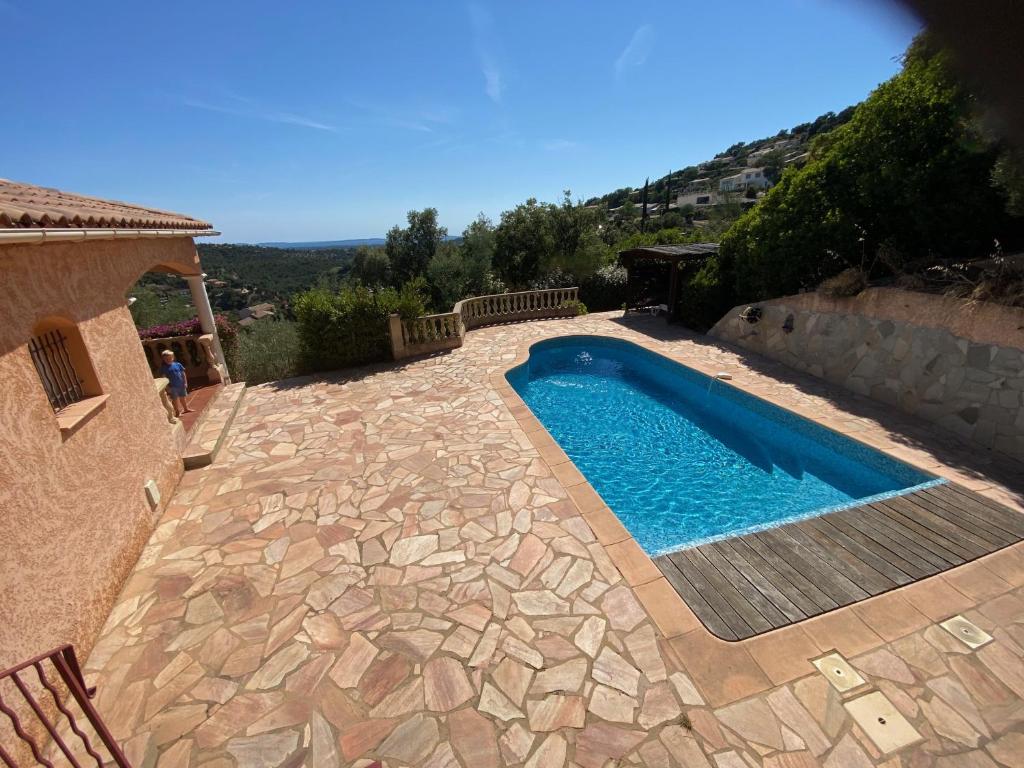 - une piscine dans une cour avec une terrasse en pierre dans l'établissement Villa Lucio, à La Londe-les-Maures