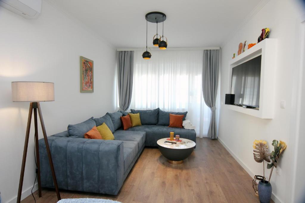 a living room with a blue couch and a table at Venima City Center Apartment in Tivat