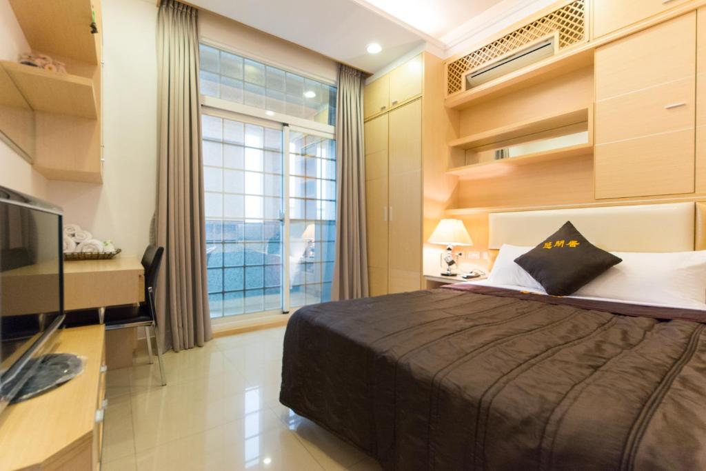 a bedroom with a bed and a tv and a window at Taitung Leisure B&B in Taitung City