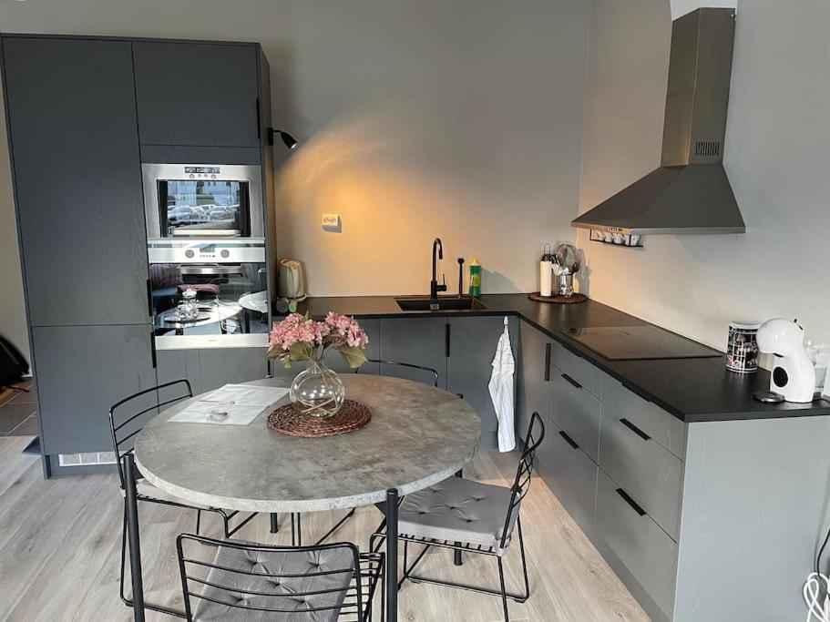 a kitchen with a table and chairs in a kitchen at Practical apartment near city center in Stavanger
