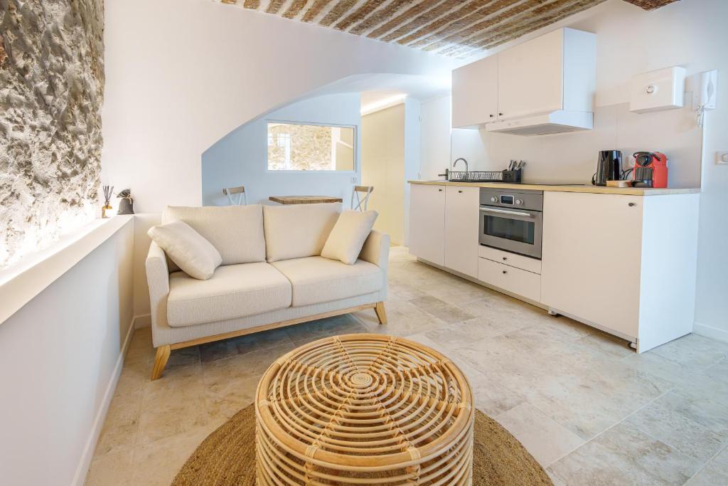 un salon avec un canapé et une cuisine dans l'établissement 2 pièces Cœur du Vieil Antibes, à Antibes