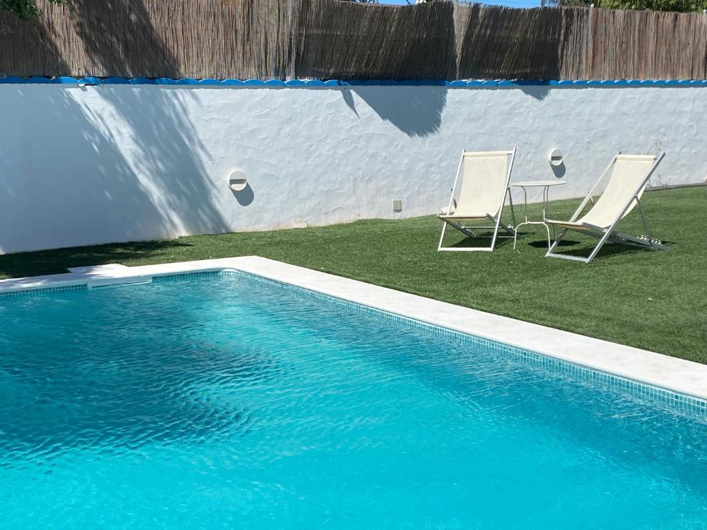 two chairs sitting next to a swimming pool at Alojamiento Rural Al´Mare in Conil de la Frontera