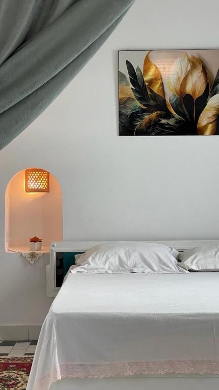 a bedroom with a bed and a painting on the wall at Flat Marina Kantaoui in Sousse