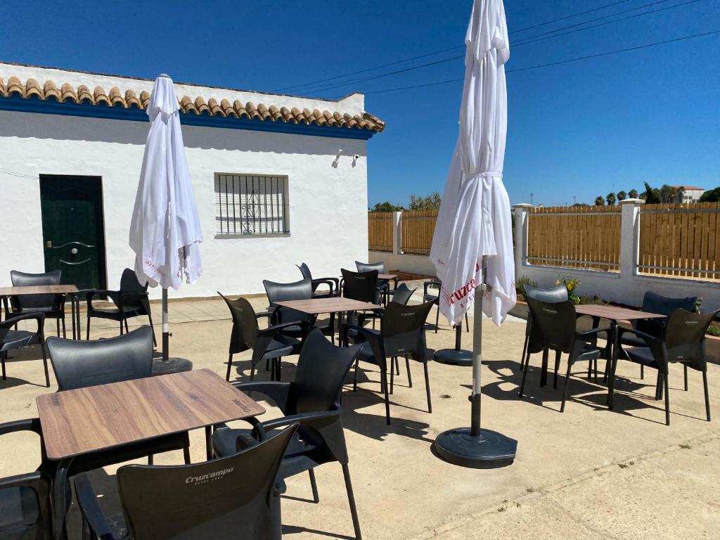 a group of tables and chairs with umbrellas at Alojamiento Rural Al´Mare in Conil de la Frontera