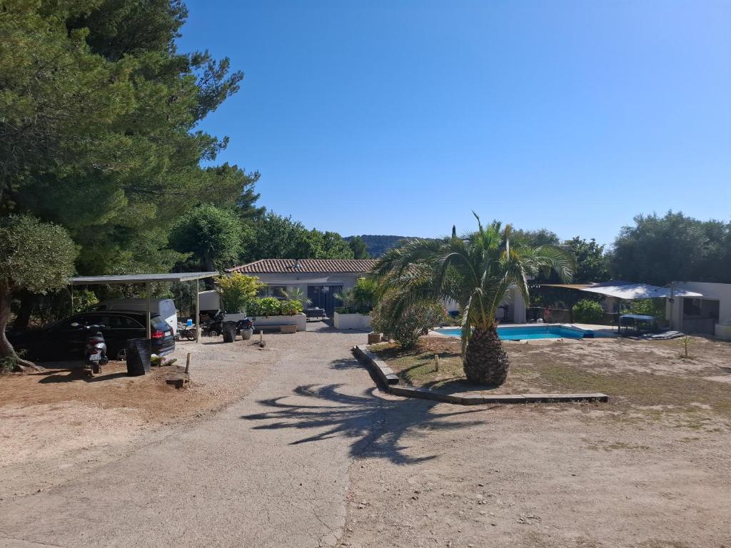 une maison avec un palmier dans l'allée dans l'établissement Maison de standing au calme pour vacances, au Beausset