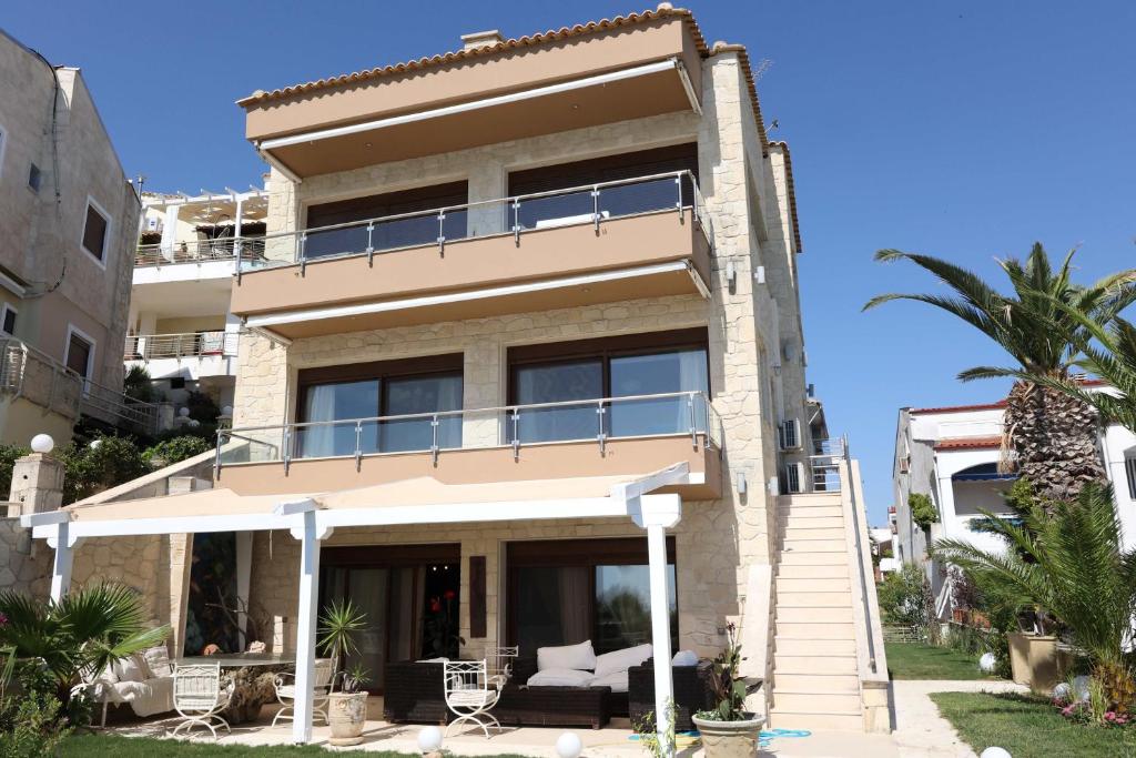 a house with a balcony and a palm tree at Villa Sunset Siviri in Siviri