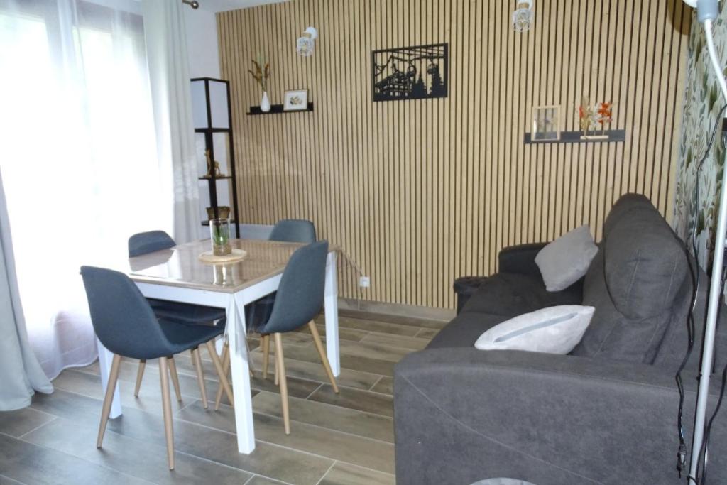 un salon avec un canapé et une table dans l'établissement Appartement 4 personnes aux Bottières Résidence le Bochate sur le domaine des Sybelles en Savoie, à Saint-Pancrace