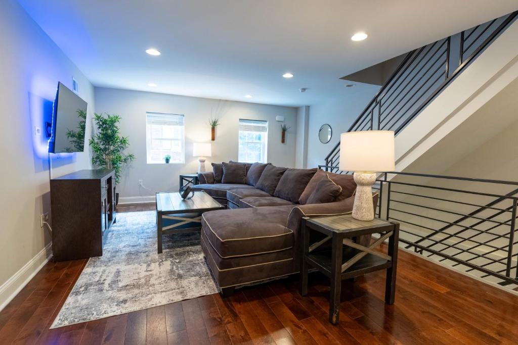 een woonkamer met een bank en een trap bij Stylish 3BR w Pool Table & Garage in Philadelphia