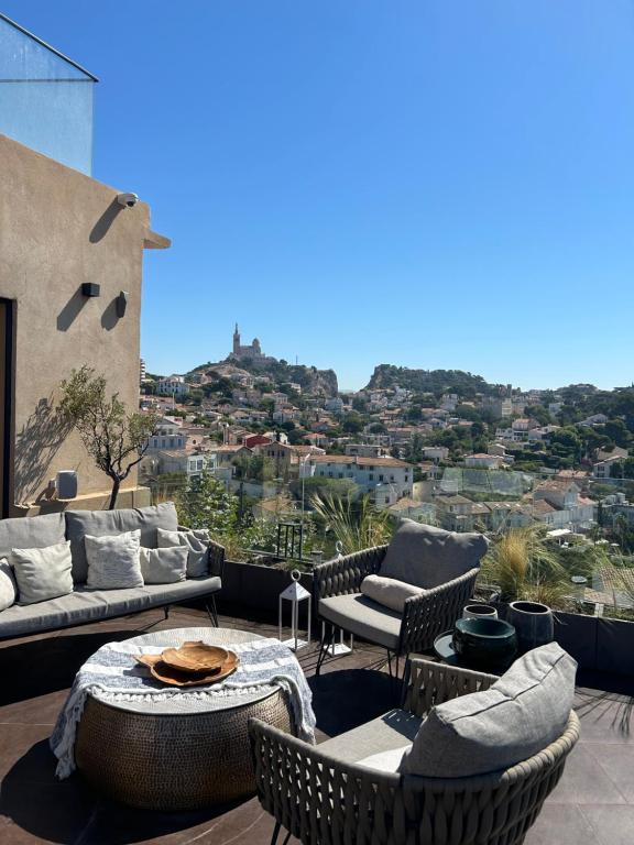 a patio with couches and a table and chairs at Maï Homes - La Villa Bompard in Marseille