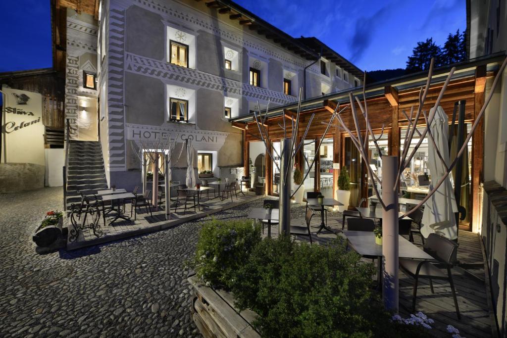 un hotel con tavoli e sedie di fronte a un edificio di Chesa Stuva Colani a Madulain