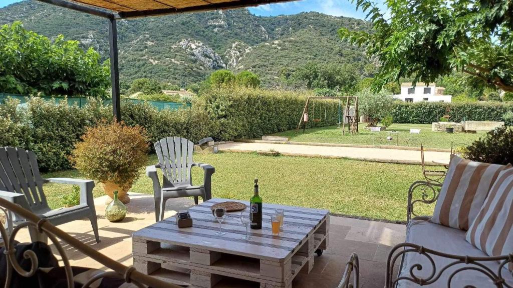- une terrasse avec une table et une bouteille de vin dans l'établissement Maison de plein pied avec vue sur le Lubéron, à Maubec