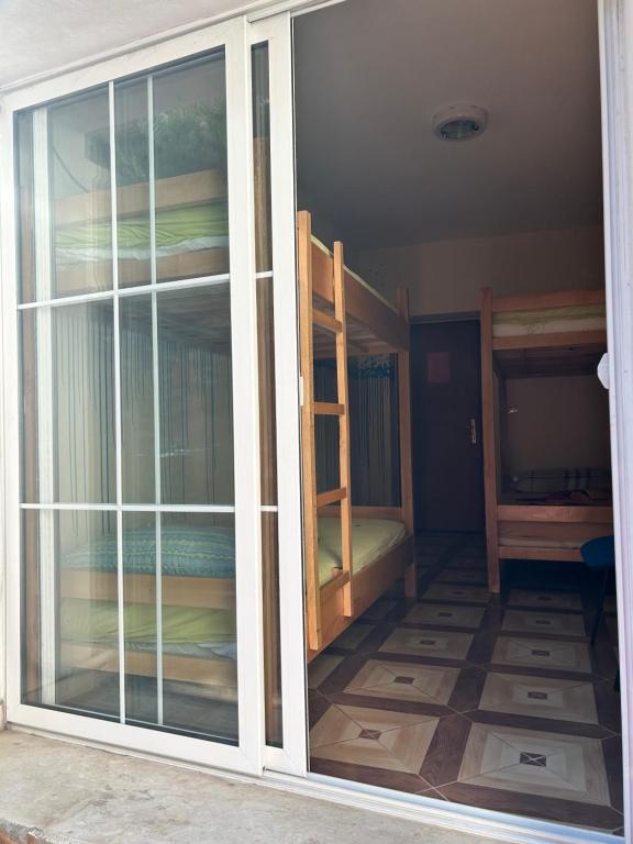 an open sliding glass door to a room with bunk beds at D1 Hostel in Tirana