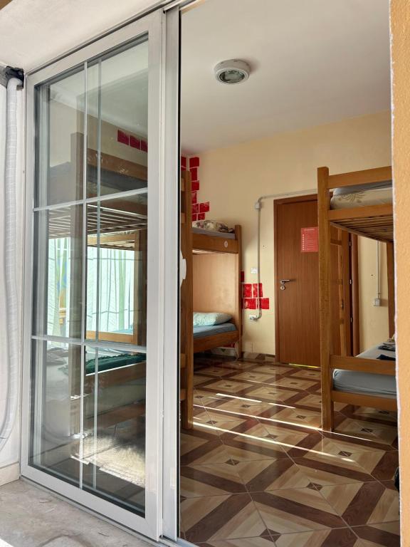 a room with bunk beds and a glass door at D1 Hostel in Tirana