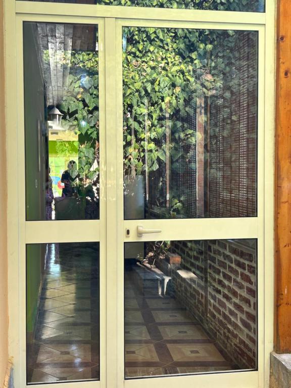 a sliding glass door with a view of a garden at D1 Hostel in Tirana