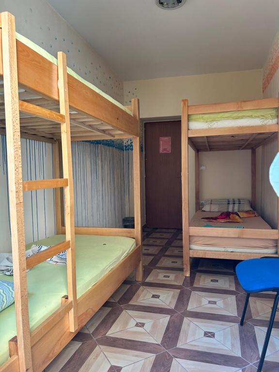 a room with three bunk beds and a chair at D1 Hostel in Tirana