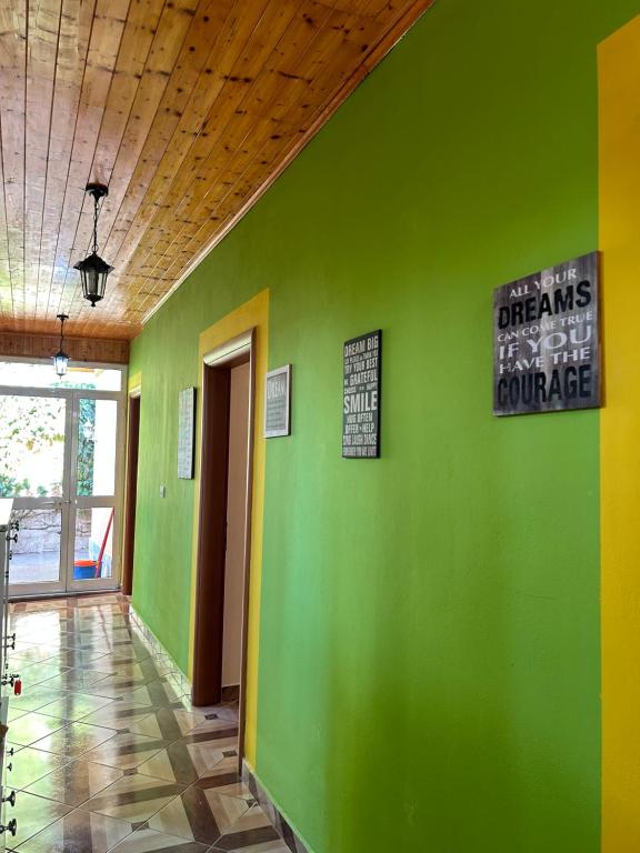 a green wall in a room with signs on it at D1 Hostel in Tirana