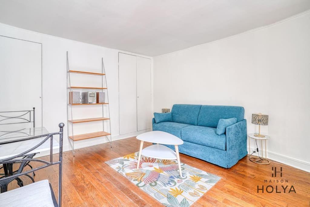 un salon avec un canapé bleu et une table dans l'établissement Proche des Champs Élysées - Le Fonctionnel - 244B, à Paris