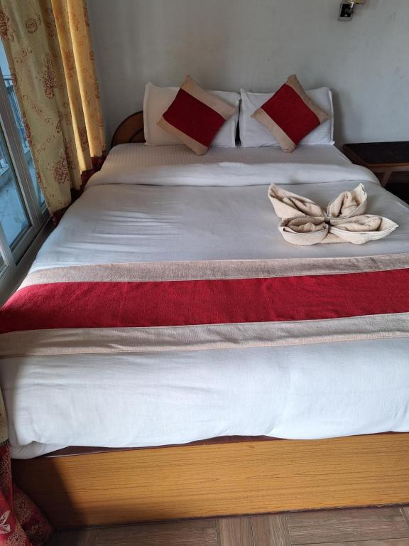 a bed with two pillows and a bow on it at Hotel Shiva's Dream in Sauraha