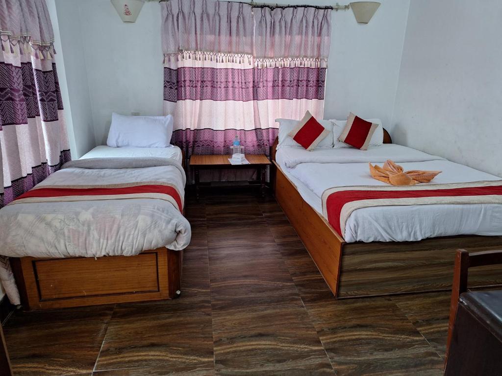 a room with two beds and a window at Hotel Shiva's Dream in Sauraha