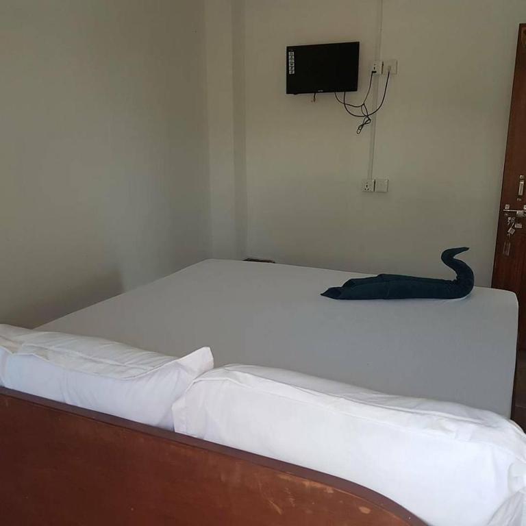 a white bed with a black snake laying on it at Hotel Shiva's Dream in Sauraha