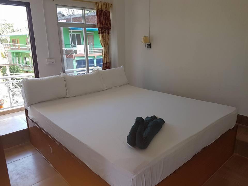 a white bed with a pair of shoes on it at Hotel Shiva's Dream in Sauraha