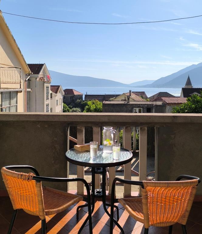 un tavolo e sedie su un balcone con vista di Apartment Marea a Tivat