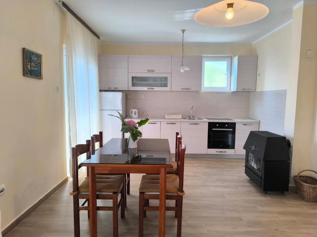 a kitchen with a dining room table with chairs and a television at Apartment Marea in Tivat