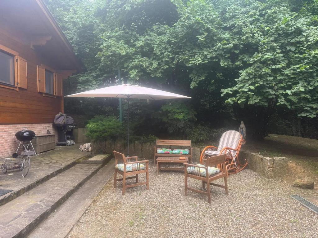 a patio with two chairs and an umbrella at Cozy Chalet in Castell'Arquato 90 m² with Private Pool in CastellʼArquato