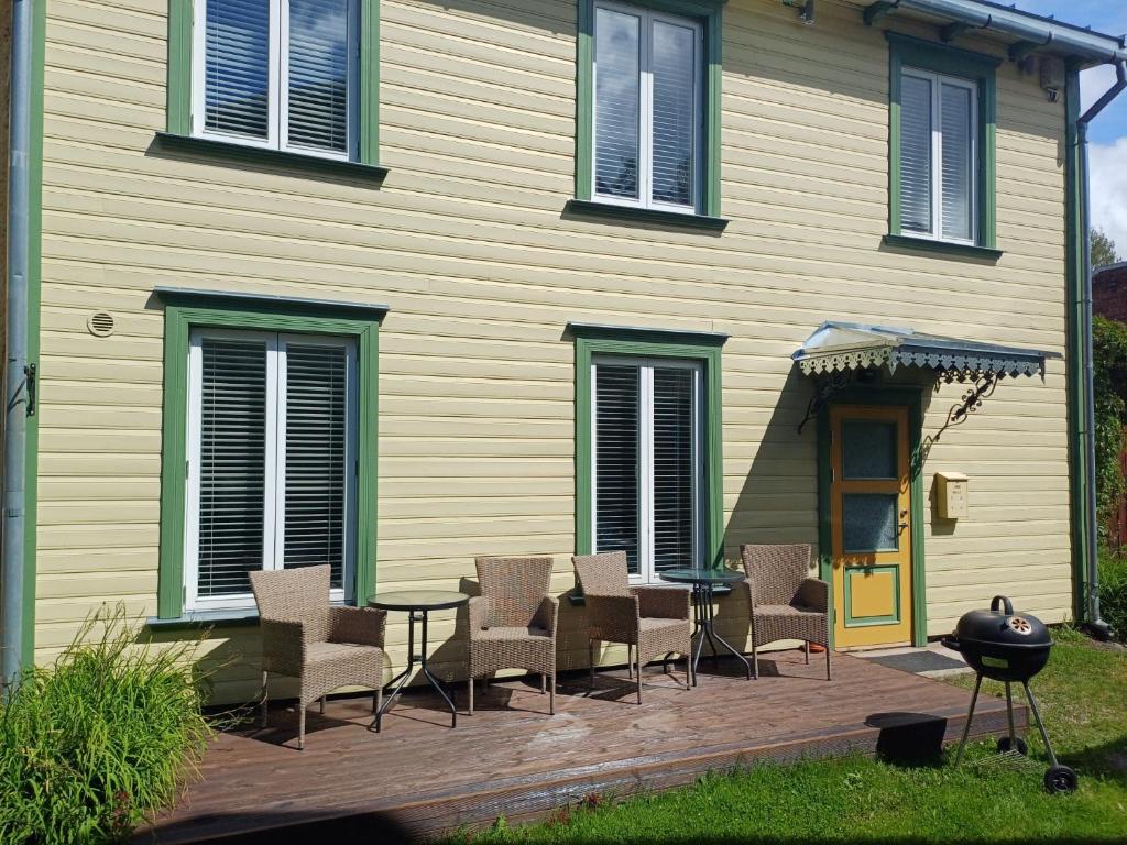 a patio with chairs and a table in front of a house at Yellow Center Holiday Home in Pärnu