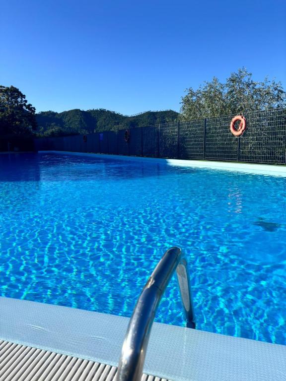 a swimming pool with blue water and a fence at casa vacanze Veronica in Soviore