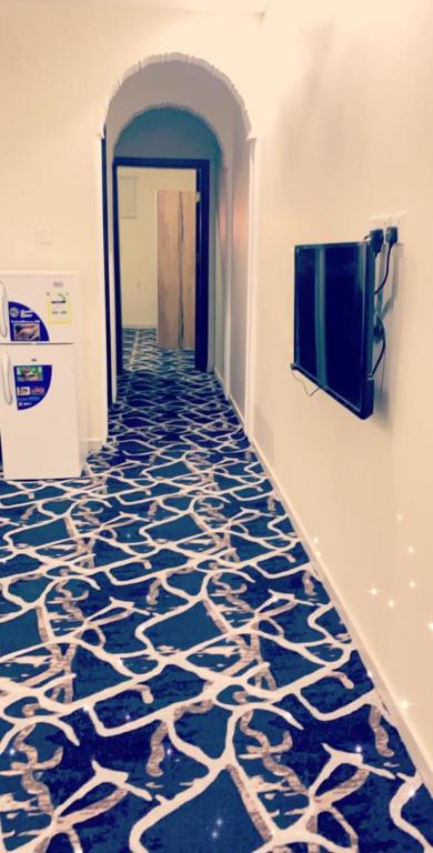 un pasillo con suelo azul y blanco estampado en شقق عزاب البوداي, en Tabuk