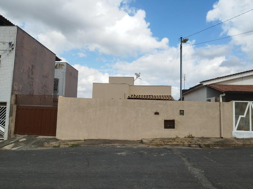 a brick wall in a parking lot next to a building at Casa aconchegante in Pará de Minas