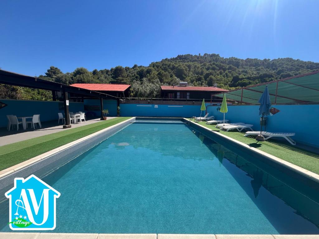 a swimming pool in a villa with a mountain in the background at Abbamala Village in Bosa