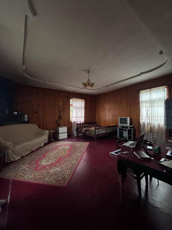 een woonkamer met een bank en een tafel bij Дом Бобоквати in Kobuleti
