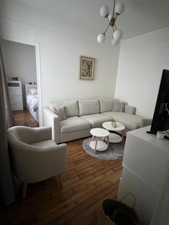 a living room with a couch and a table at Appartement Porte de Versailles in Issy-les-Moulineaux