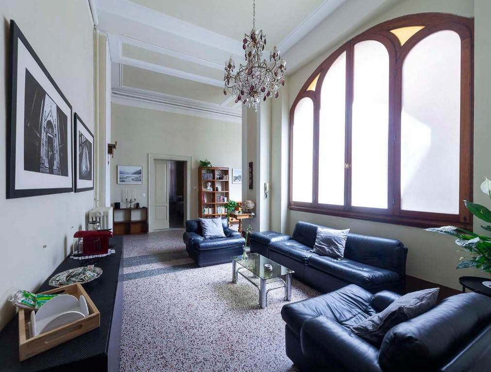 una sala de estar con sofás azules y una lámpara de araña. en B&B del Corso, en Ascoli Piceno