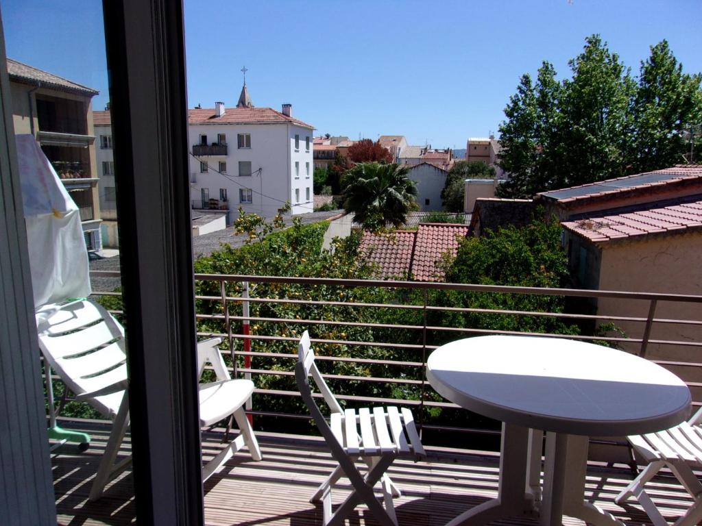 d'un balcon avec une table et des chaises offrant une vue sur la ville. dans l'établissement Confort et lumière, à Sanary-sur-Mer