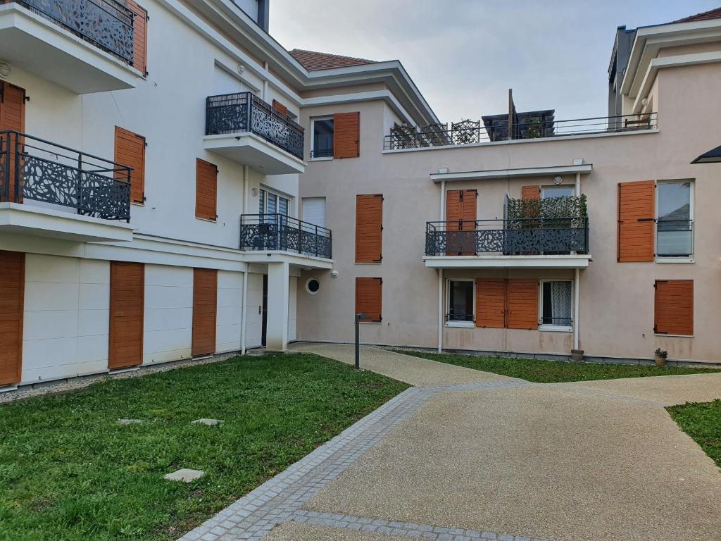 un immeuble d'appartements avec balcon et allée. dans l'établissement Appartement Cormeilles, à Cormeilles-en-Parisis