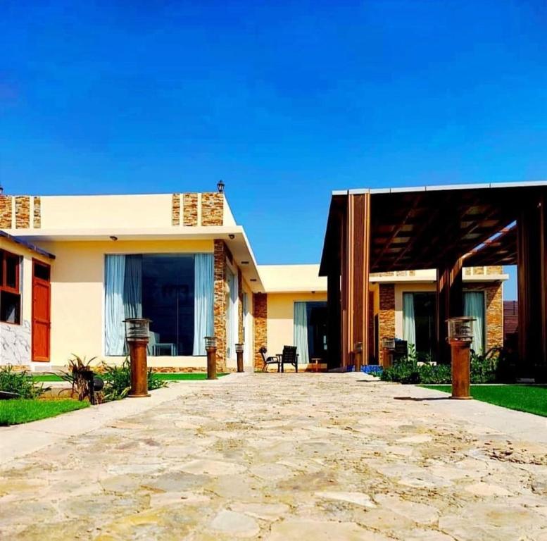 Una casa con un camino de piedra al frente. en Oasis Chalet - Sahanawt, en Salalah