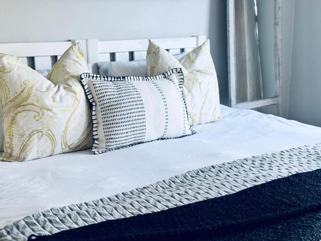a bed with white sheets and pillows on it at Studio #2 in East London