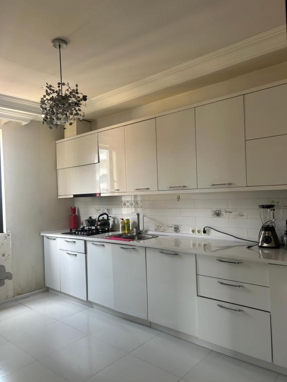 a white kitchen with white counters and white cabinets at Kobuleti Family apartment in K'obulet'i