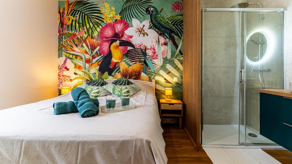 une chambre avec un lit avec un tableau sur le mur dans l'établissement Le Chouette Toucan, à Dijon