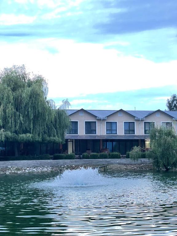 a large building next to a body of water at Laguna City Lux in Tegirmenty