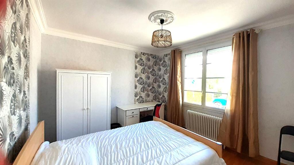 une chambre avec un lit et une fenêtre dans l'établissement Douceur Vendéenne, à La Roche-sur-Yon