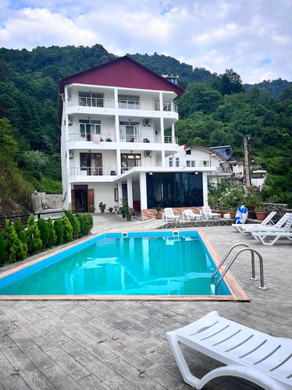 a hotel with a swimming pool in front of a building at Zuri Kvariati in Kvariati