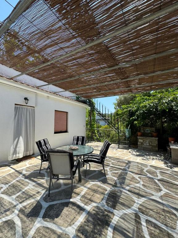 a patio with a table and chairs under a pergola at Naia House in Chorefto