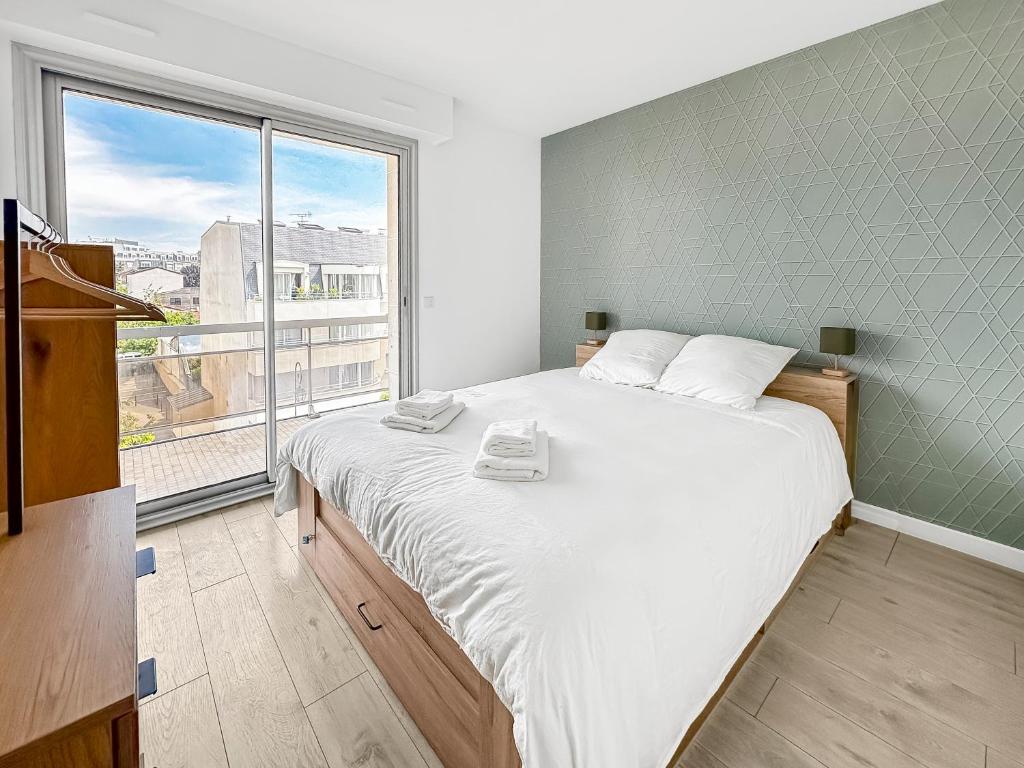 une chambre avec un grand lit et une grande fenêtre dans l'établissement Détente Près de la Capitale à Antony, à Antony
