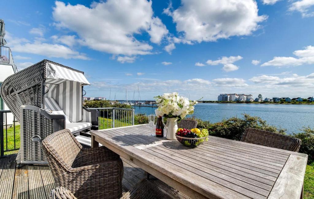 a wooden table on a deck with a view of the water at Am Yachthafen in Olpenitz